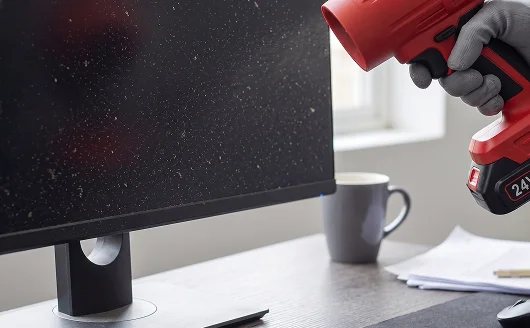 Blower aimed near a dusty computer monitor.